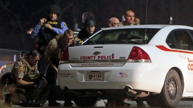 Police in riot gear respond to demonstrators blocking outside the Ferguson Police Department on 11 March